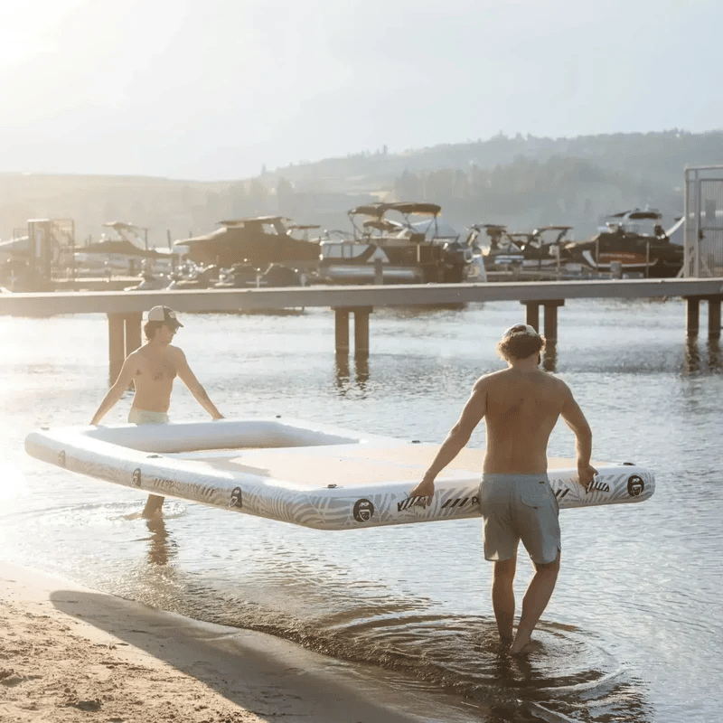 2 People carrying a POP AquaDock 14' × 7' Inflatable Floating Dock Platform 