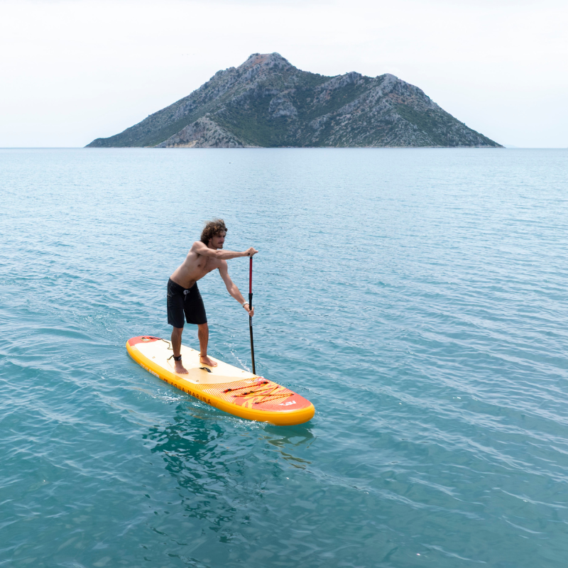 A Man Riding a Aqua Marina Fusion 10'10" all-around inflatable SUP 