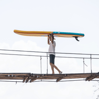 Thumbnail for A man carrying POP Yacht Hopper 11' Inflatable Touring Paddle Board SUP – Turq/Neon/Pink on his head
