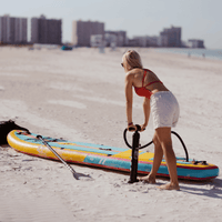 Thumbnail for A person is inflating a POP Yacht Hopper 11' Inflatable Touring Paddle Board SUP – Turq/Neon/Pink with a hand pump
