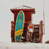 Thumbnail for A surfer is relaxing with a POP Yacht Hopper 11' Inflatable Touring Paddle Board SUP – Turq/Neon/Pink