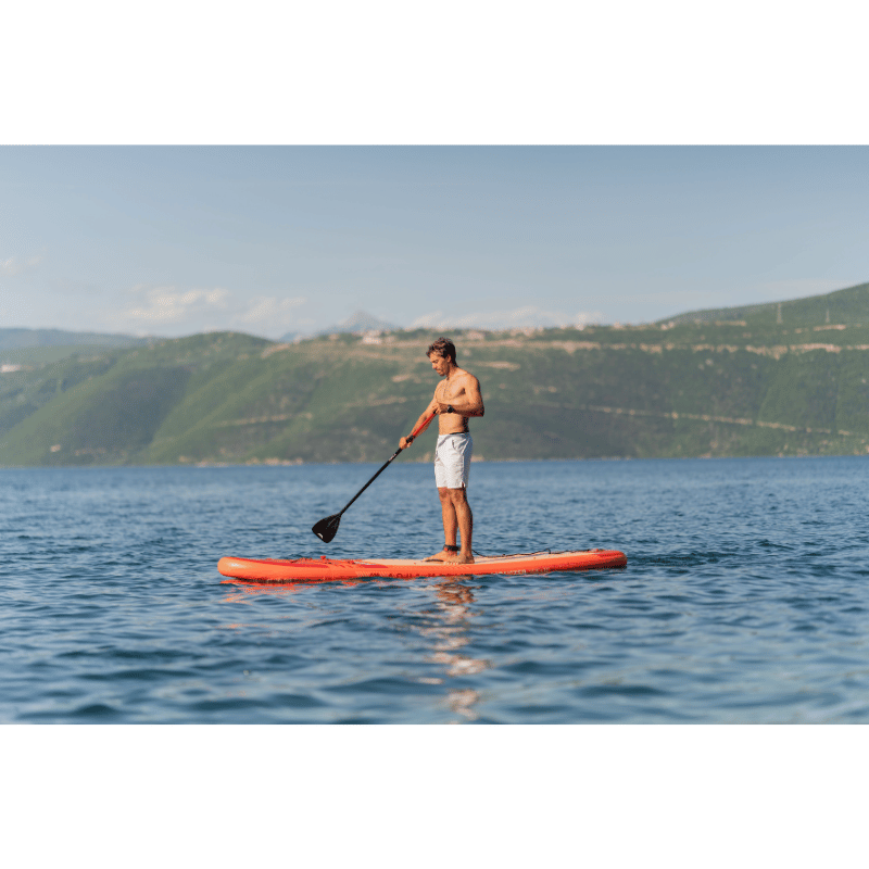 A man riding a Aqua Marina 12'0" MONSTER 2026 Inflatable Paddle Board on a Calm Lake