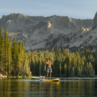 Thumbnail for Lifestyle photo of a man on a POP Yacht Hopper 11' Inflatable Touring Paddle Board SUP – Turq/Neon/Pink on a lake